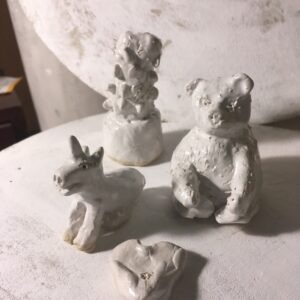 auf dem bild sidn vier weiß glasierte kleinformatige Keramikplastiken zu sehen, die bei einem Kinderworkshop entstanden sind: ein Einhorn, ein Bär ein Herz und ein Kaktus